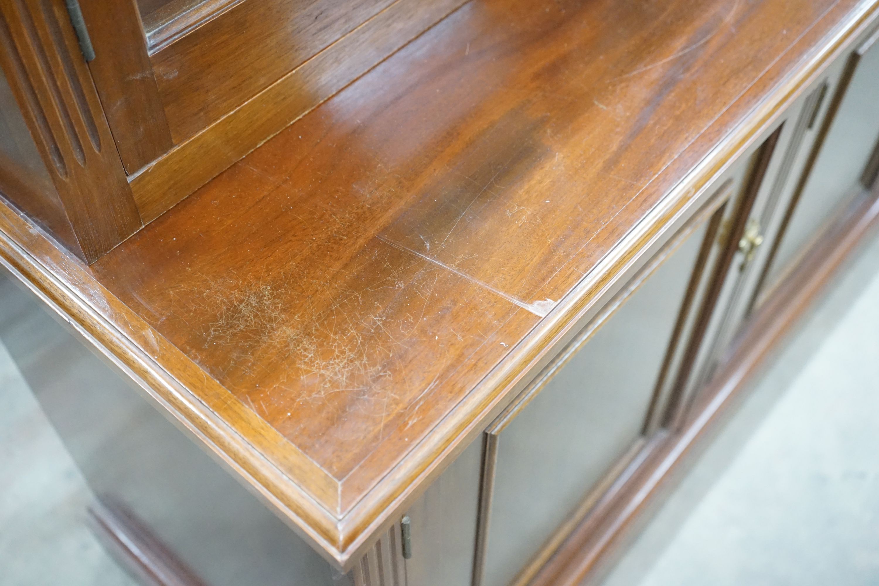 A Victorian style four section mahogany library bookcase, the upper section fitted clear glazed doors above further panelled doors on plinth base, length 216cm, depth 51cm, height 215cm